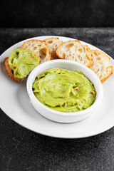 Guacamole dip avocado sauce cold appetizer vegetables dish organic fresh tasty gourmet food background on the table rustic food top view copy space keto and paleo diet vegetarian and vegan food