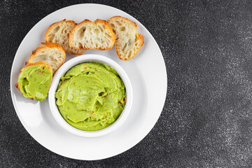 Guacamole dip avocado sauce cold appetizer vegetables dish organic fresh tasty gourmet food background on the table rustic food top view copy space keto and paleo diet vegetarian and vegan food