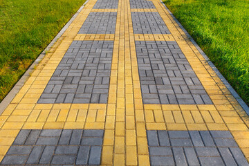 Fototapeta premium A walking path lined with yellow and black tiles