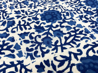 An intricate blue floral block print flows elegantly across pristine white cotton, evoking timeless...