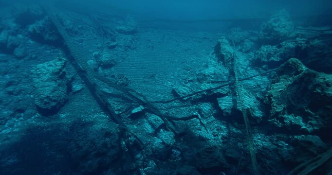 Underwater view in deep crystal lake with sunken wooden logs and stones. Most transparent Paisu pok lake in Indonesia. 