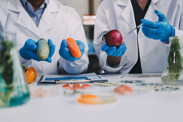 Team Asian scientists in a lab conducting food research using a microscope and lab equipment,...