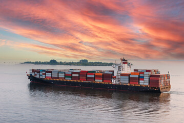 Fully loaded cargo container ship departing from port of Tanjung Pelepas on her international trade route.