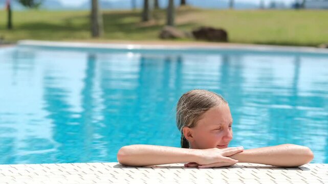 12 year old blond girl enjoying the sun in the pool, children's holidays