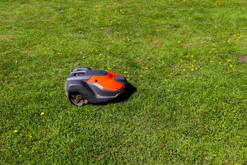 A robotic lawn mower mows the lawn.