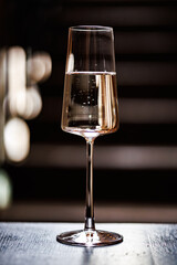 A sparkling drink in a sleek, tall glass, beautifully captured with rich reflections and soft bokeh in a moody, elegant setting
