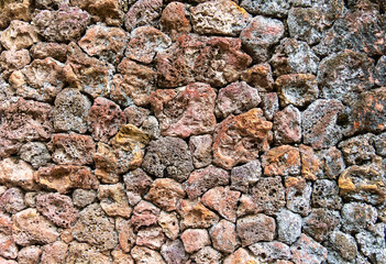 colored unprocessed rocky stones of natural origin, a wall of stones in concrete, background for walls and wallpapers