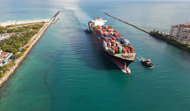 Export and import. Cargo business. Port of Miami. Cargo ship with container, aerial. Freight container on cargo vessel. Cargo ship vessel leaving port. Container ship. Global supply chain backbone