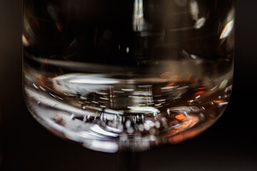 A close-up of a glass filled with red wine, showcasing delicate bubbles and rich hues against a softly blurred background, evoking an air of sophistication and celebration