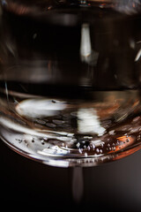A close-up of a glass filled with red wine, showcasing delicate bubbles and rich hues against a softly blurred background, evoking an air of sophistication and celebration