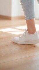 Experiencing Pain: Woman Grabbing Achilles Heel in Discomfort on Wooden Floor with Natural Lighting