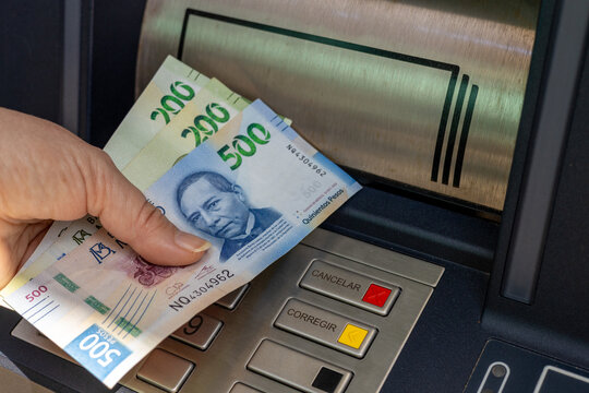 Mexico money. A woman withdraws money from an ATM. Financial concept. Mexican peso