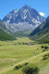 Majestic mountain scenery with lush green valley and small village under clear blue sky in summer day perfect for travel