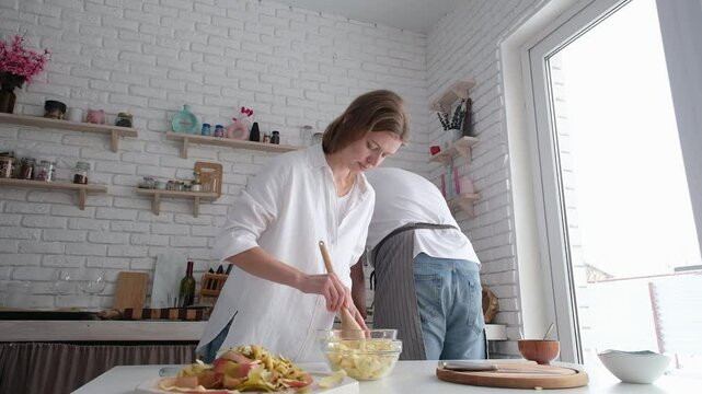 happy couple having wonderful time while cooking apple strudel in a cheerful atmosphere together. Kitchen, housework, home, relationship