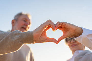 Love heart shape peace. Senior older couple making heart shape with their hands. Adult mature old husband wife showing heart sign. Happy pensioner family. I love you happy valentines day