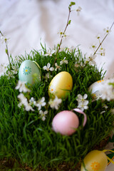 Colorful decorative eggs are nestled in a bed of vibrant green grass.
