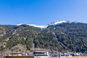 Snow-dusted alpine slopes above residential area, Ötztal, Austria, 20 March 2025..
