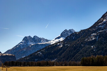 Snowy alpine peaks and forested slopes under blue sky, Ötztal, Austria, 20 March 2025..