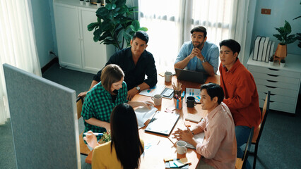 Top view of manager present idea while colleague helping explain idea and answering question. Group...