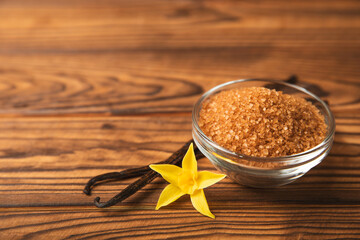 Aromatic vanilla sugar. Vanilla pods. Vanilla sticks, brown and white sugar in a bowl on a textured background. Vanilla flowers, spices and herbs for desserts and baking. Space for text. Copy space