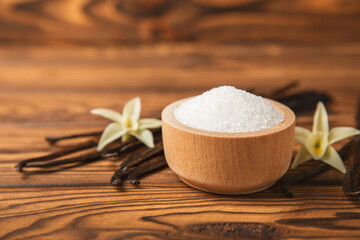 Aromatic vanilla sugar. Vanilla pods. Vanilla sticks, brown and white sugar in a bowl on a textured background. Vanilla flowers, spices and herbs for desserts and baking. Space for text. Copy space