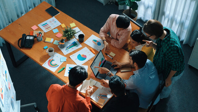Top down view of multicultural business group putting hand together to celebrate increasing sales or successful project. Close up of marketing team making stack of hand and clapping hand. Convocation.