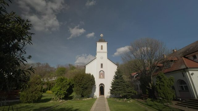 White Orthodox Church with Bell Tower Surrounded by Tees Religious Architecture