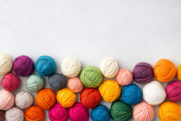 Collection of colorful yarn balls in assorted shades arranged on white background with copy space, knitting and crafting concept
