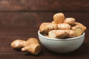 Fresh ginger on wooden background. Dry ginger. Sliced ​​ginger with honey and lemon. Ginger root. Traditional alternative medicine, healing tea for immunity. Seasoning and spices concept. Copy space.