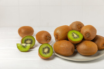 Kiwi on wooden background. Whole fruit and slices pieces of green kiwi on table. fresh ripe juicy...