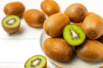 Kiwi on wooden background. Whole fruit and slices pieces of green kiwi on table. fresh ripe juicy kiwi. Tropical fruit. Organic fruit. Healthy eating. Space for text. Copy space