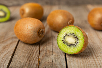 Kiwi on wooden background. Whole fruit and slices pieces of green kiwi on table. fresh ripe juicy kiwi. Tropical fruit. Organic fruit. Healthy eating. Space for text. Copy space