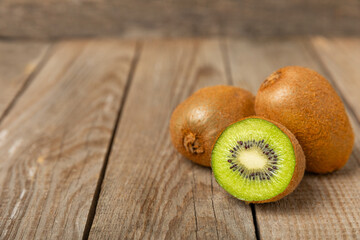 Kiwi on wooden background. Whole fruit and slices pieces of green kiwi on table. fresh ripe juicy...