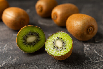 Kiwi on wooden background. Whole fruit and slices pieces of green kiwi on table. fresh ripe juicy...