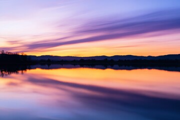 Obraz premium Vibrant sunset casts colorful reflections over tranquil lake at dusk near mountains