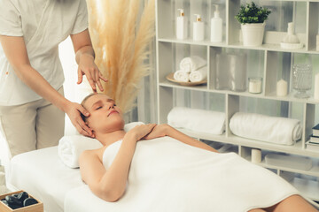 Caucasian woman enjoying relaxing anti-stress head massage and pampering facial beauty skin...