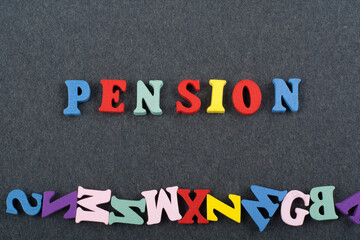 Obraz premium PENSION word on black board background composed from colorful abc alphabet block wooden letters, copy space for ad text. Learning english concept.