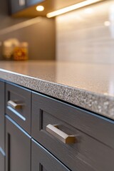 Modern kitchen with sleek dark cabinets and granite countertop under warm lighting.
