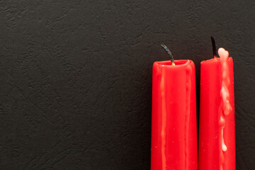 Two red candles on black background