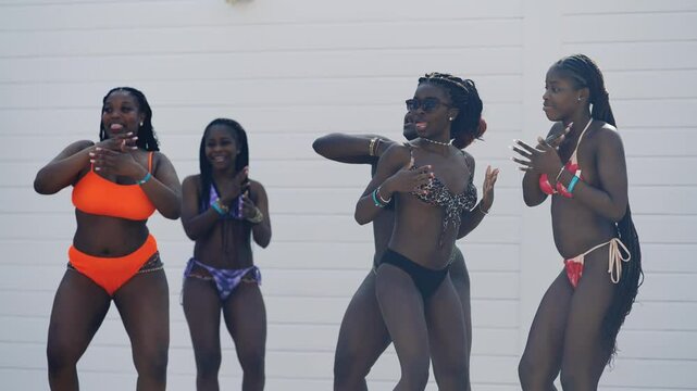 African women group enjoying a lively moment while dancing by the pool, showcasing vibrant summer energy and celebration, slow motion
