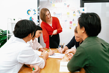 Happy cooperative multi-ethnic business group brainstorming discussion about marketing plan by...