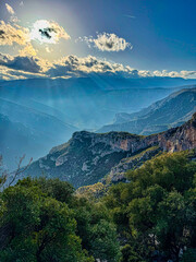 LENS FLARE: Sunlight pierces through clouds, casting beams over mountain ridges near Leonidio,...