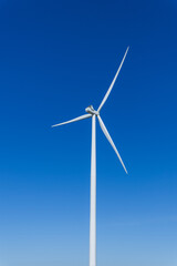 Wind turbine generating electricity in the blue sky background.