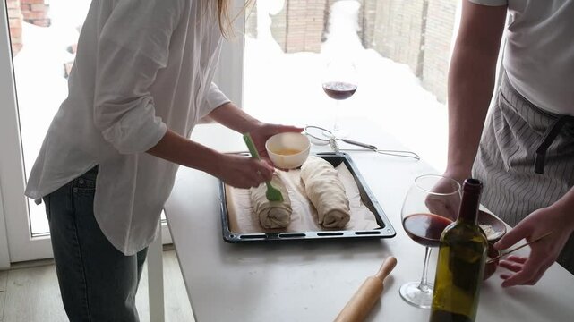 happy couple having wonderful time while cooking apple strudel in a cheerful atmosphere together. Kitchen, housework, home, relationship