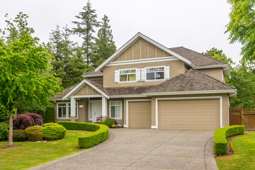 Garage door in luxury house with trees and nice landscape in Summer in Vancouver, Canada, North America. Day time on June 2024.