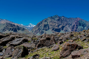 Andes mountains beautiful landscape in early spring with melting snow on the mountain slopes and lakes. Volcano San Jose in the high altitude Andes in Santiago de Chile area