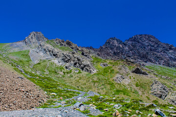 Fototapeta premium Andes mountains beautiful landscape in early spring with melting snow on the mountain slopes and lakes. Volcano San Jose in the high altitude Andes in Santiago de Chile area
