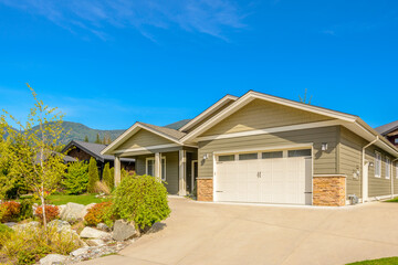 Garage door in luxury house with trees and nice landscape in Summer in Vancouver, Canada, North America. Day time on June 2024.