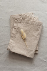 Сloth napkins in a warm colors on a beige cotton tablecloth. Minimalistic composition with natural...