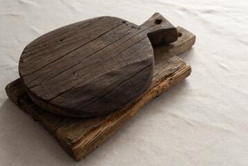 Wooden kitchen boards on a beige cotton tablecloth. Minimalistic composition with natural elements...